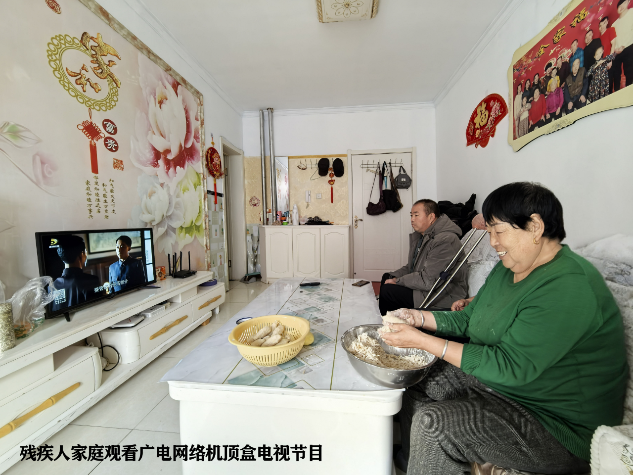 图为残疾人家庭观看广电网络机顶盒电视节目